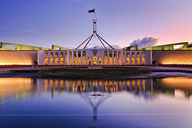 CAN parliament Set reflect colourful reflection of Canberra's new parliament building in a fontain pond at sunset. coat of arms photos stock pictures, royalty-free photos & images