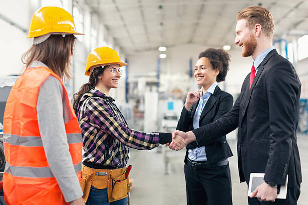 инспекторы контроля качества на фабрике встряхивая руки с миру - manual worker handshake industry warehouse стоковые фото и изображения