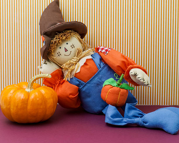 istock Silly Scarecrow Leaning Against Pumpkin 518096463