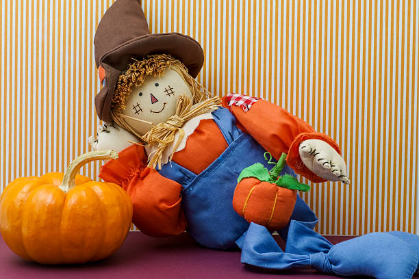 istock Silly Scarecrow Leaning Against Pumpkin 518096477