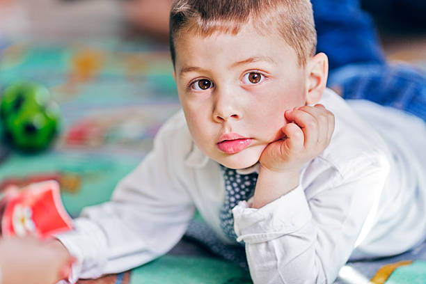 istock Cute Little Boy in White Playing in a kindergaten 518097092