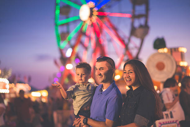 Fun at the Fair Parents with a young child at a country fair. Shot in Midland, MI. agricultural fair photos stock pictures, royalty-free photos & images