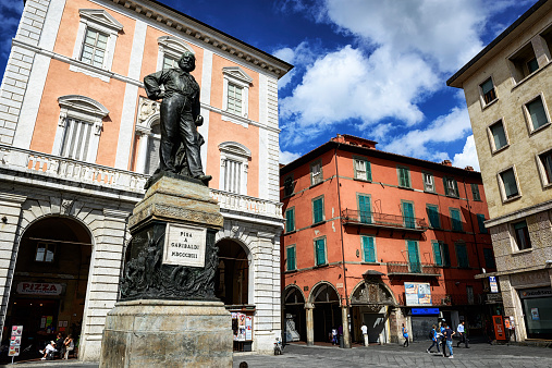 Pisa, Italy - September 16, 2013: Piazza del Pozzetto in Pisa, Italy. People walking in town square with old buildings and statue of Garbaldi.