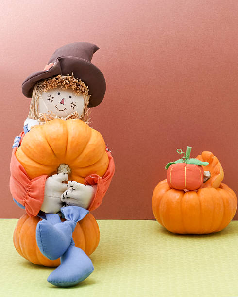 istock Holiday Scarecrow Cradles A Pumplin 518097397