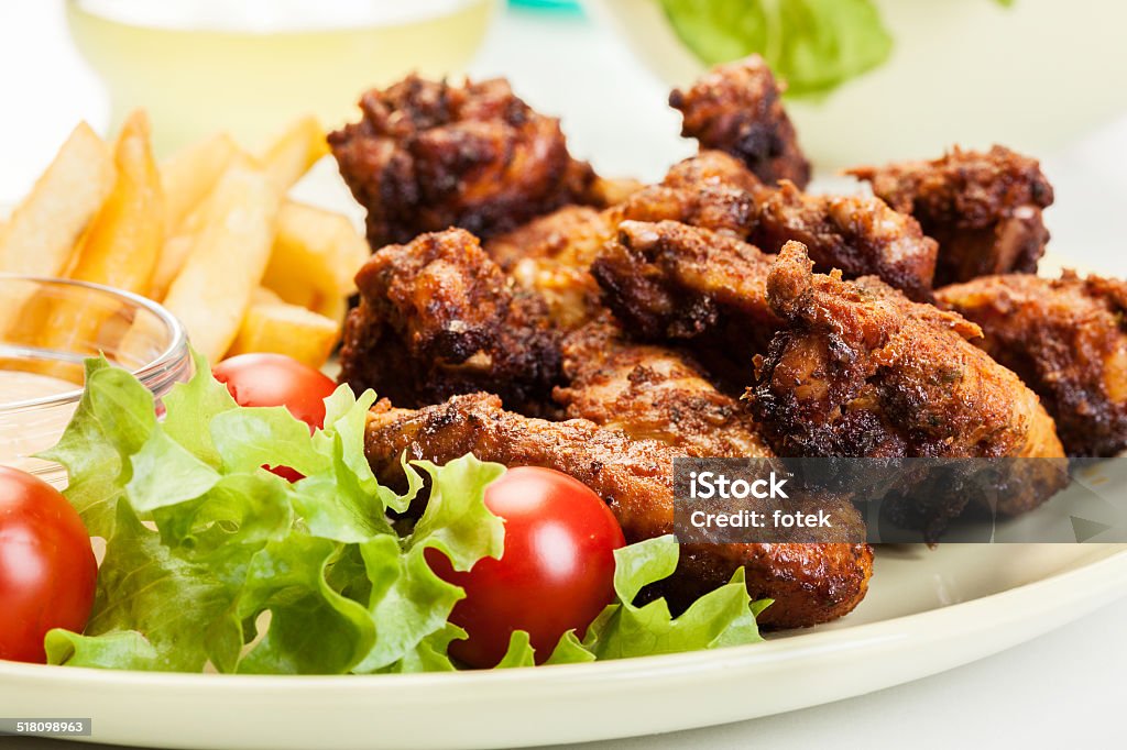 Alitas de pollo con salsa picante papas fritas y francesa - Foto de stock de Ala de animal libre de derechos