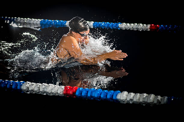 Woman Swimming The Breaststroke Professional female swimmer performing the breaststroke.   women exercising swimming pool young women stock pictures, royalty-free photos & images