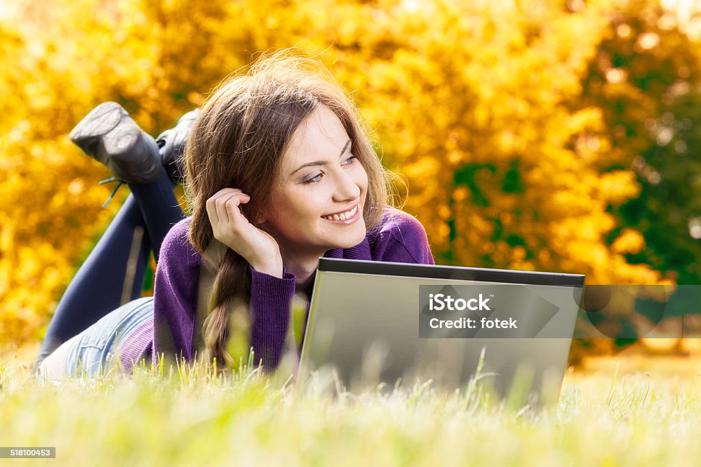 Mujer con ordenador portátil en el otoño de paisaje - Foto de stock de Abrigo libre de derechos