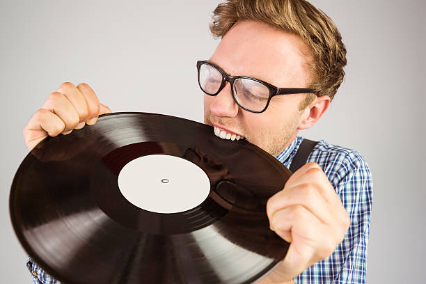istock Geeky hipster biting vinyl record 518101179