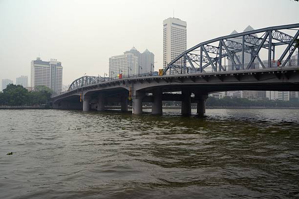Guangzhou, China - April 20, 2014: Haizhu Bridge, an iron bridge across the Pearl River in Guangzhou, under polluted sky. Haizhu Bridge was the first bridge to be built across the Pearl River in Guangzhou. Guangdong