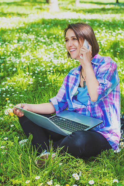 istock Young woman in nature with technology 518110688