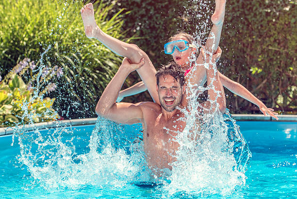 istock Father and daughter playing in a pool 518116684
