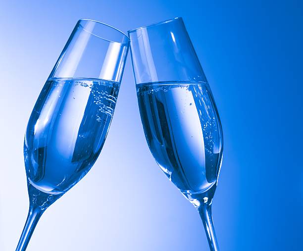 Two glasses of champagne on classic blue bokeh background. Holiday concept. Festive bokeh background. Horizontal, toned