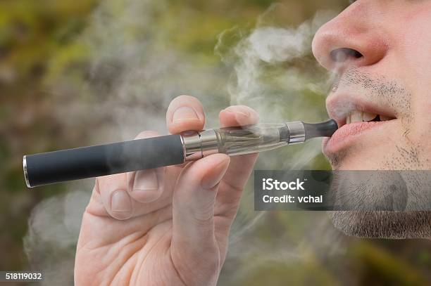 Young Smoker Is Vaping Ecigarette Or Vaporizer Stock Photo - Download Image Now - Electronic Cigarette, Quitting Smoking, Addiction