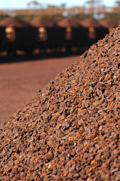 Section of iron ore stockpiles. Brown red stockpiles of crushed iron ore waiting for shipment. A detailed view of a stockpile of crushed iron ore. Reclaimer stock pictures, royalty-free photos & images