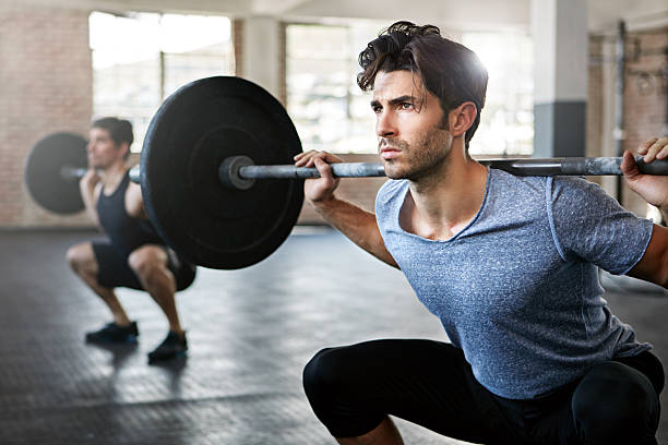 Clean and jerk! Shot of young men working out with weights in the gym weight training stock pictures, royalty-free photos & images