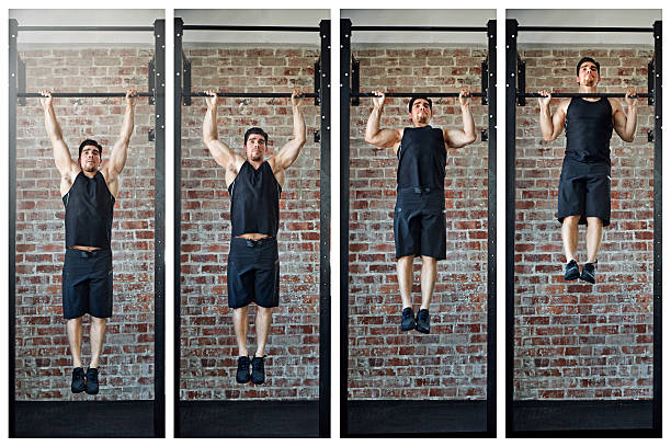 Making gains Shot of a young man doing pull ups in a gym chin ups photos stock pictures, royalty-free photos & images