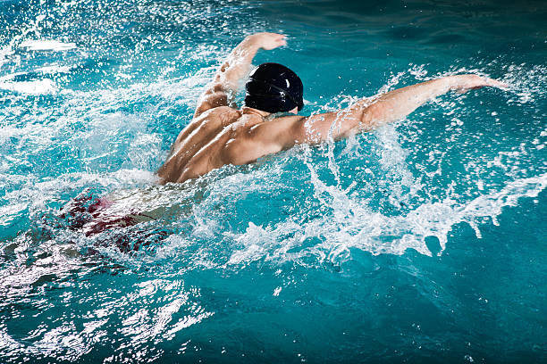 junger mann mit einem gesunden körper schwimmt muskeln - breaststroke stock-fotos und bilder