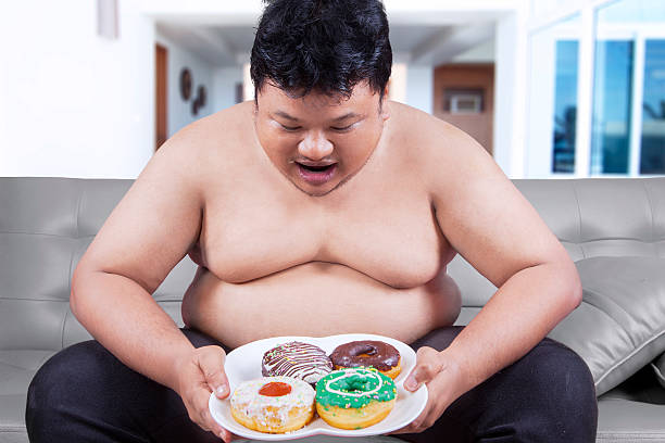 istock Fat man holding a plate of donuts 518140750