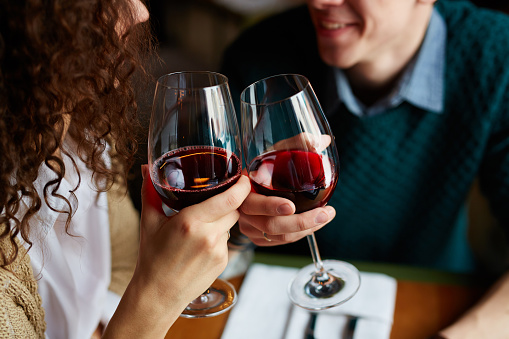 Amorous couple toasting with red wine in restaurant