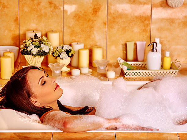 Woman relaxing at bubble bath Woman relaxing at water in luxury home bubble bath. girls bath stock pictures, royalty-free photos & images