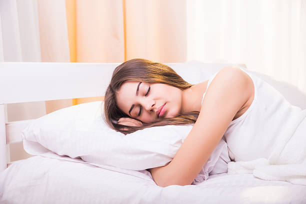 istock Woman sleeping. Beautiful young smiling woman sleeping in bed 518145570