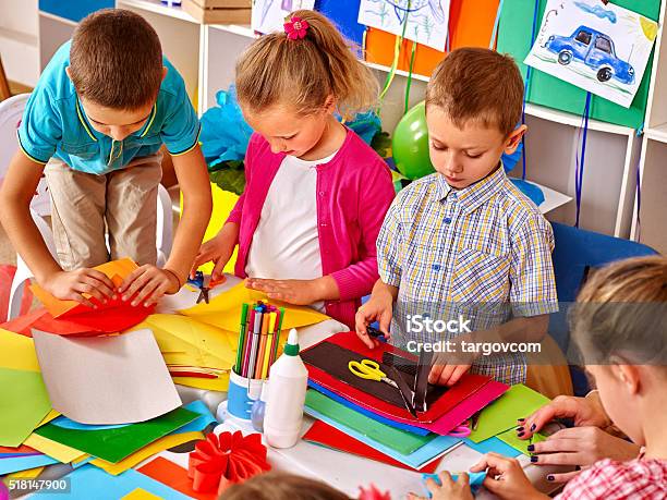 Kids Holding Colored Paper On Table In Kindergarten Stock Photo - Download Image Now