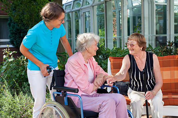 istock Elderly lady with a carer talking to friend. 518148355