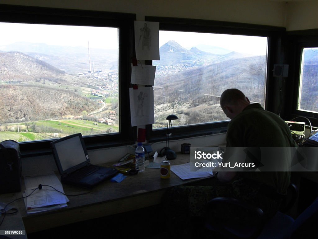 Stationed in the Radio Tower: A Lonely Assignment On Patrol - A lone soldier sitting in a radio tower with a wonderful view -  This is the real thing from KFOR, Kosovo 1999. This image is part of our historic collection. The digital cameras available back then where very bad, so expect exceptionally bad image quality Kosovo Stock Photo