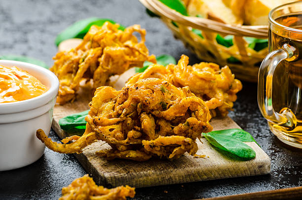 Crispy Onion Bhajis Crispy Onion Bhajis with creame cheese dip with jalapeno and crunchi toast on spinach leaves and czech beer fritter photos stock pictures, royalty-free photos & images