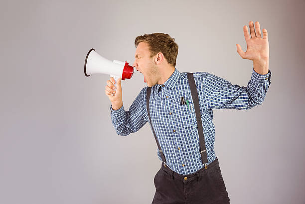 istock Geeky hipster shouting through megaphone 518149609