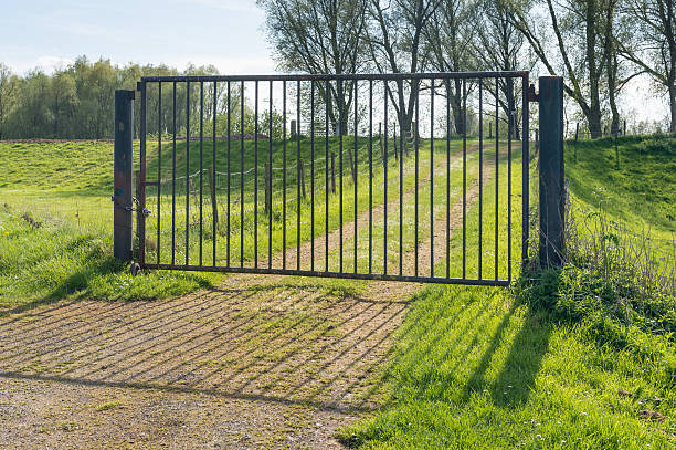 istock Closed iron gate in a rural landscape 518153241
