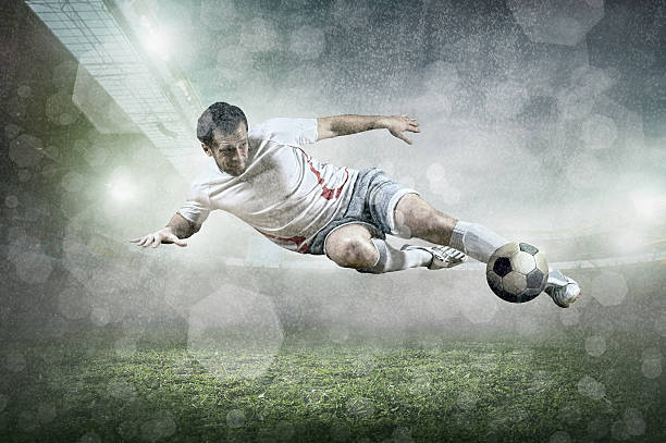 istock Soccer player with ball in action at stadium under rain. 518171364