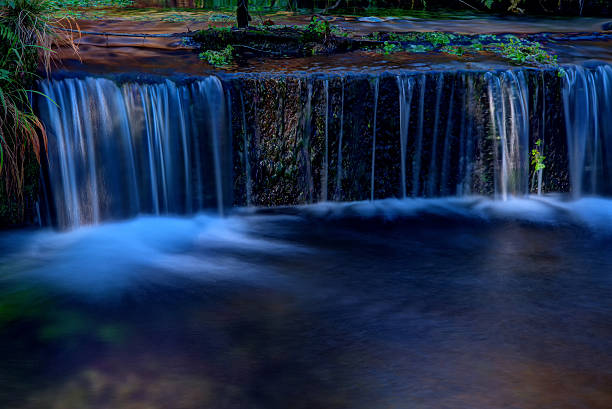 istock Water stream flowing over the concrete ledge 518171784