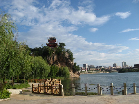 Chinese Pagoda river views scenery. Sunshine and blue skies. Bamboo tree lined river bank.