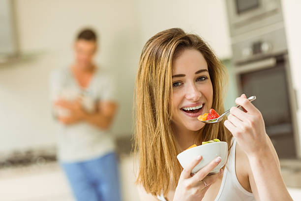 istock Woman eating fruit salad at breakfast 518172225