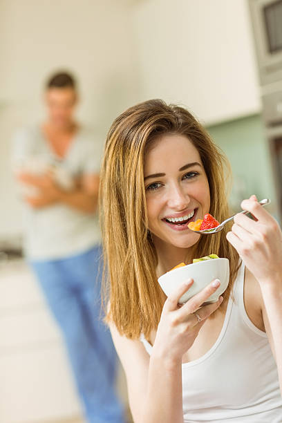 istock Woman eating fruit salad at breakfast 518172229