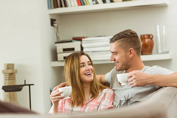 istock Cute couple relaxing on couch with coffee 518173923