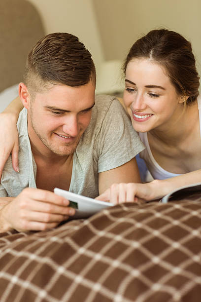 istock Cute couple reading newspaper in bed 518176509