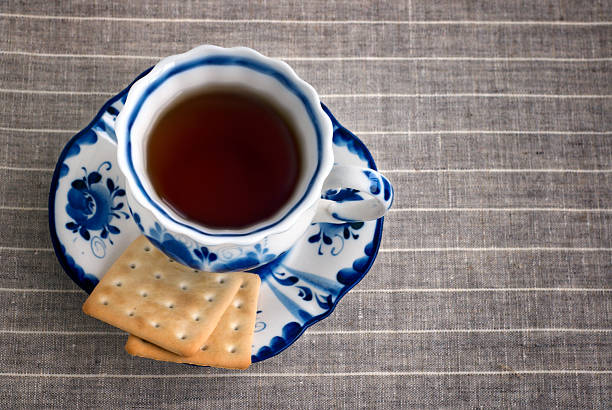 istock Black tea with crackers served in porcelain cup with saucer 518177774