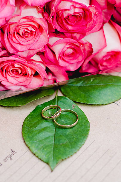 istock Set wedding rings on bouquet flowers roses. rustic style 518178322