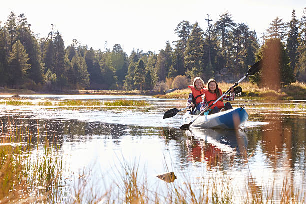 istock Mother and daughter kayaking on lake, front view 518182716