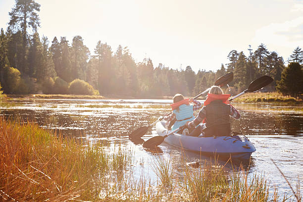 istock Mother and daughter kayaking on lake, back view 518182728
