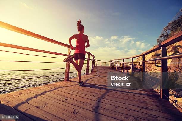 Young Fitness Woman Running On Seaside Wooden Boardwalk Stock Photo - Download Image Now