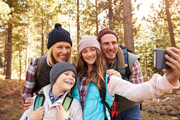 istock Family on hike in a forest taking selfie group portrait 518184810
