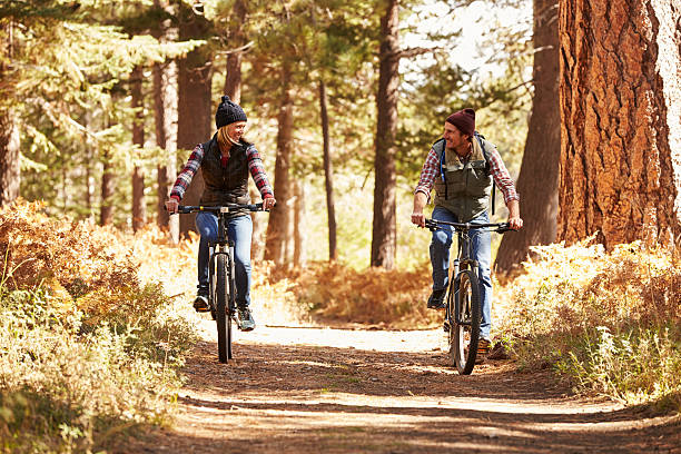 マウンテンバイクカップルまで森林、カリフォルニア州 - adult autumn couple face to face ストックフォトと画像