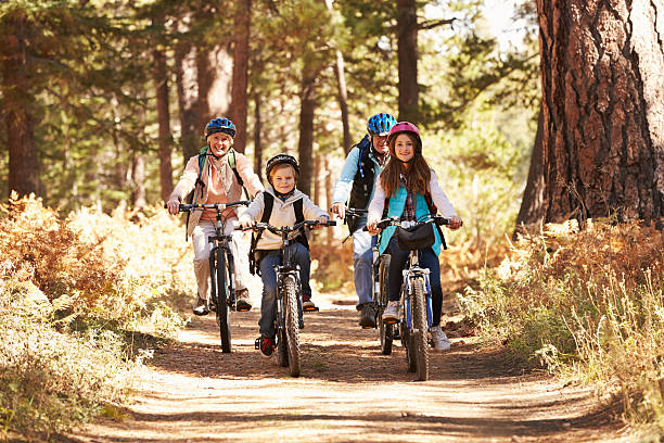 großeltern und kinder, die radfahren im wald, kalifornien - family four people smiling autumn stock-fotos und bilder