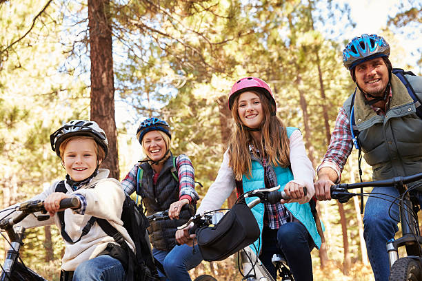 istock Family mountain biking in a forest, looking to camera 518185548