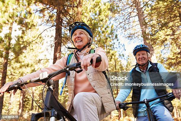Senior Couple Mountain Biking On A Forest Trail Low Angle Stock Photo - Download Image Now