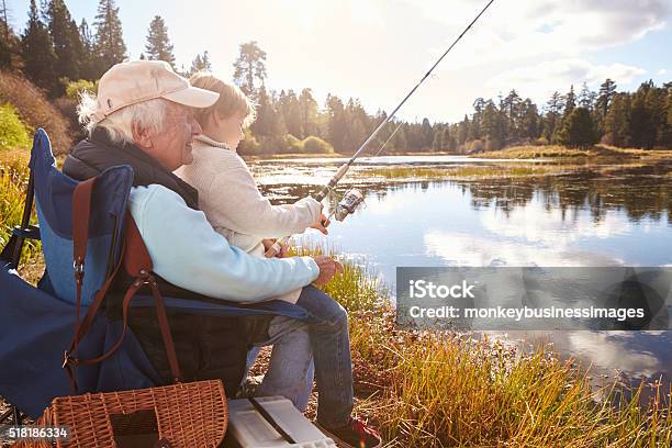 Senior Man Teaching His Grandson To Fish At A Lake Stock Photo - Download Image Now - Fishing, Senior Adult, Grandson