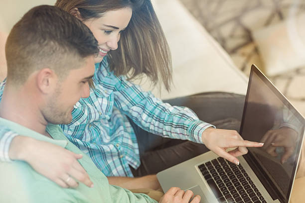 istock Cute couple relaxing on couch with laptop 518197529
